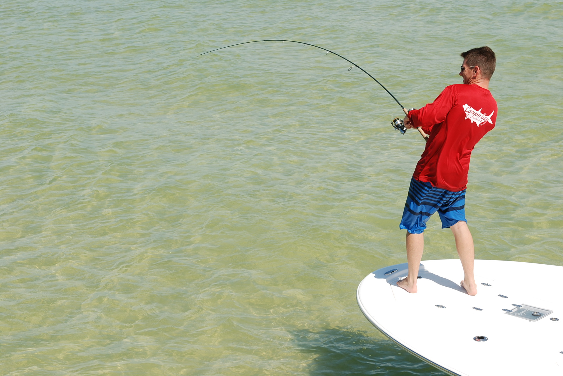 Angler casting from the bow of a Canyon Bay